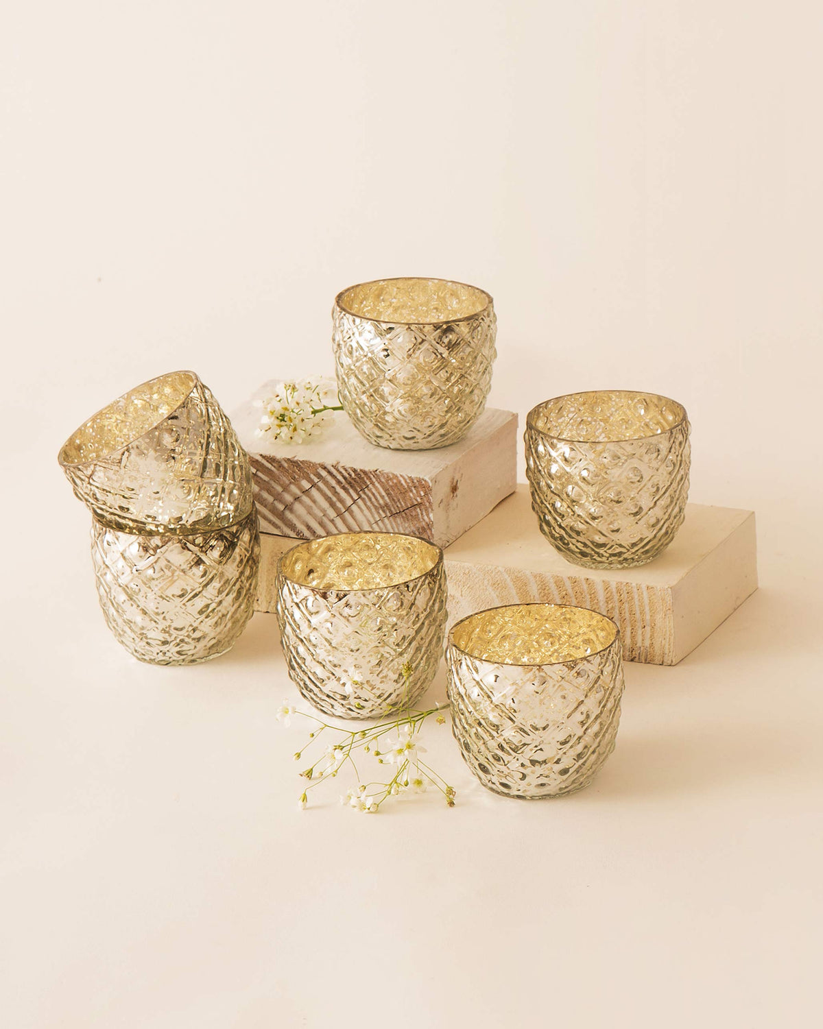 Set of six Ziya Votive holders in a gold finish.