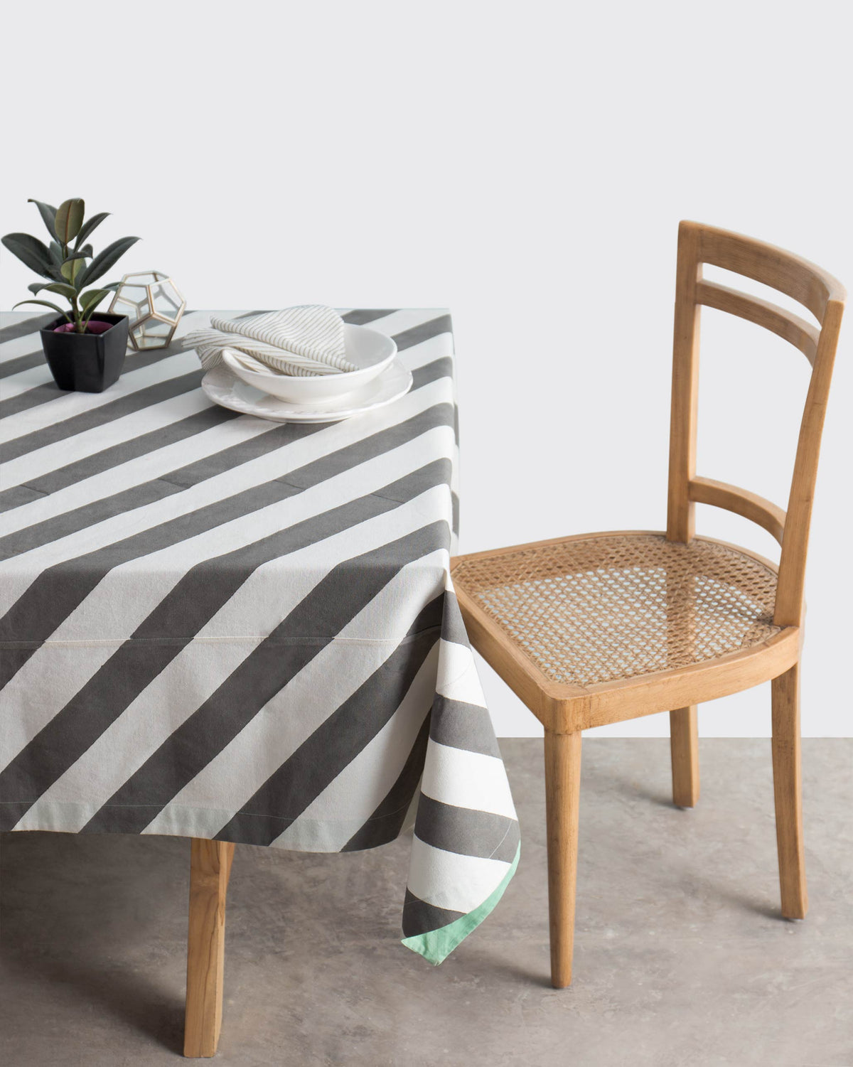 Verandah candy stripe tablecloth draped over a dining table.