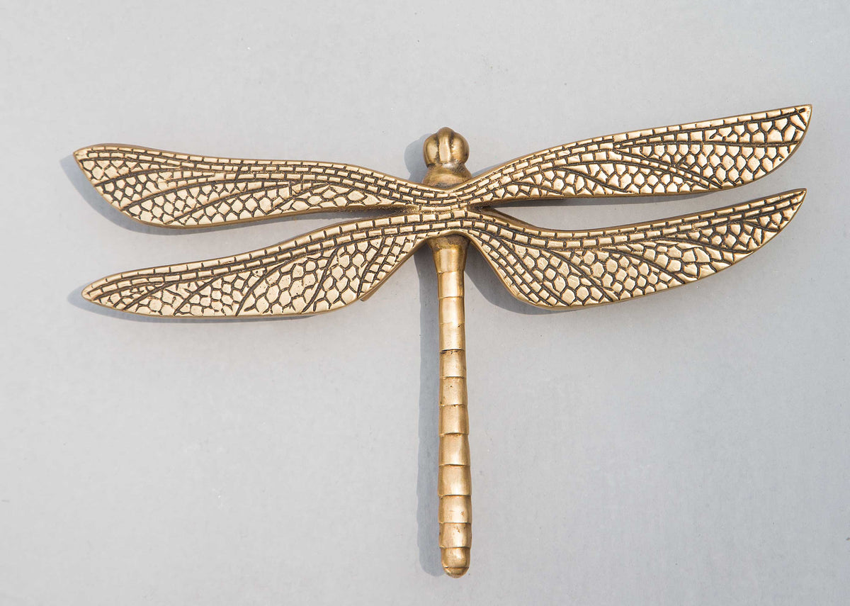 Overhead gold brass dragonfly accent piece with textured wings.