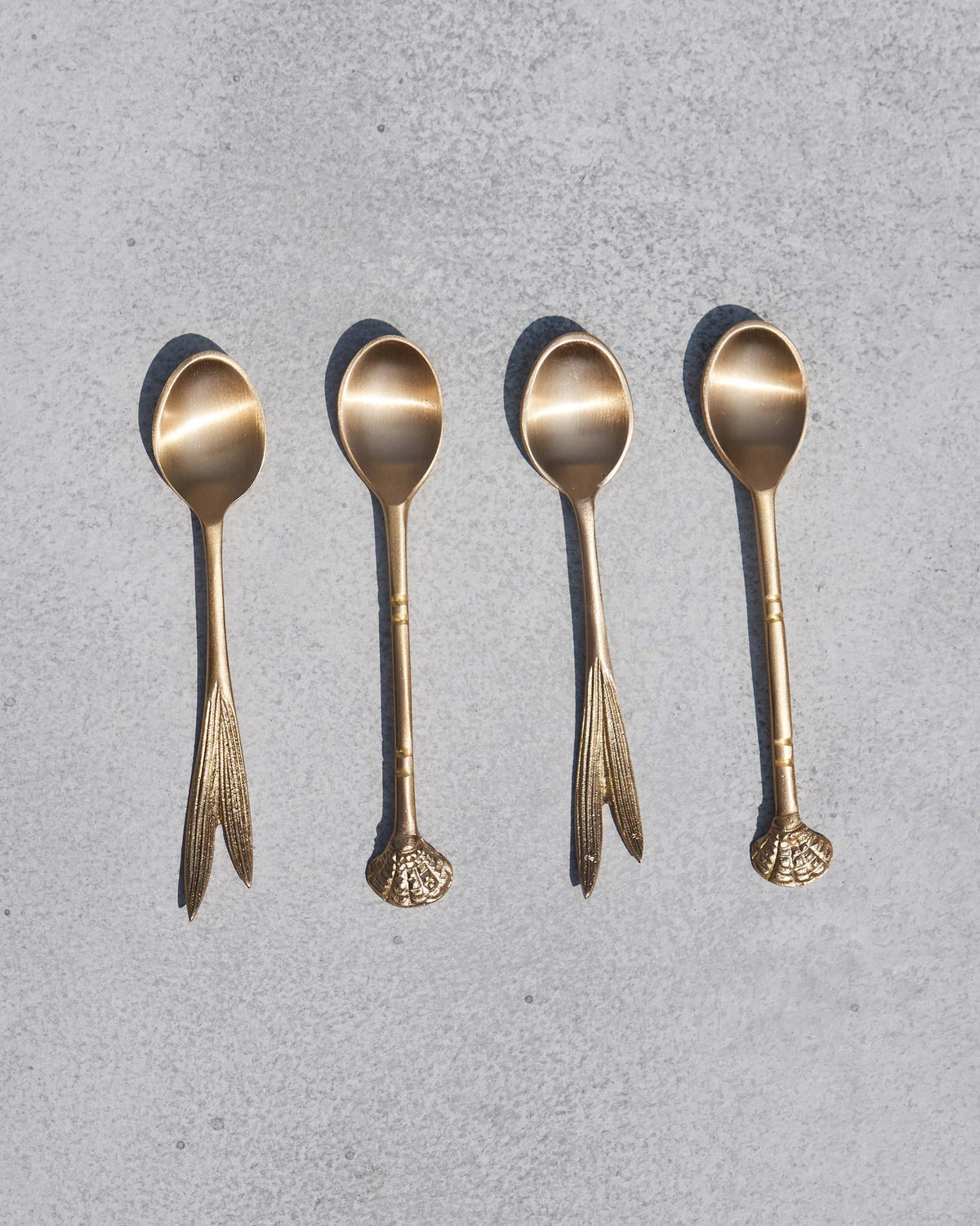 Set of four Bahr coffee spoons, two with leaf handles and two with shell-shaped ends.