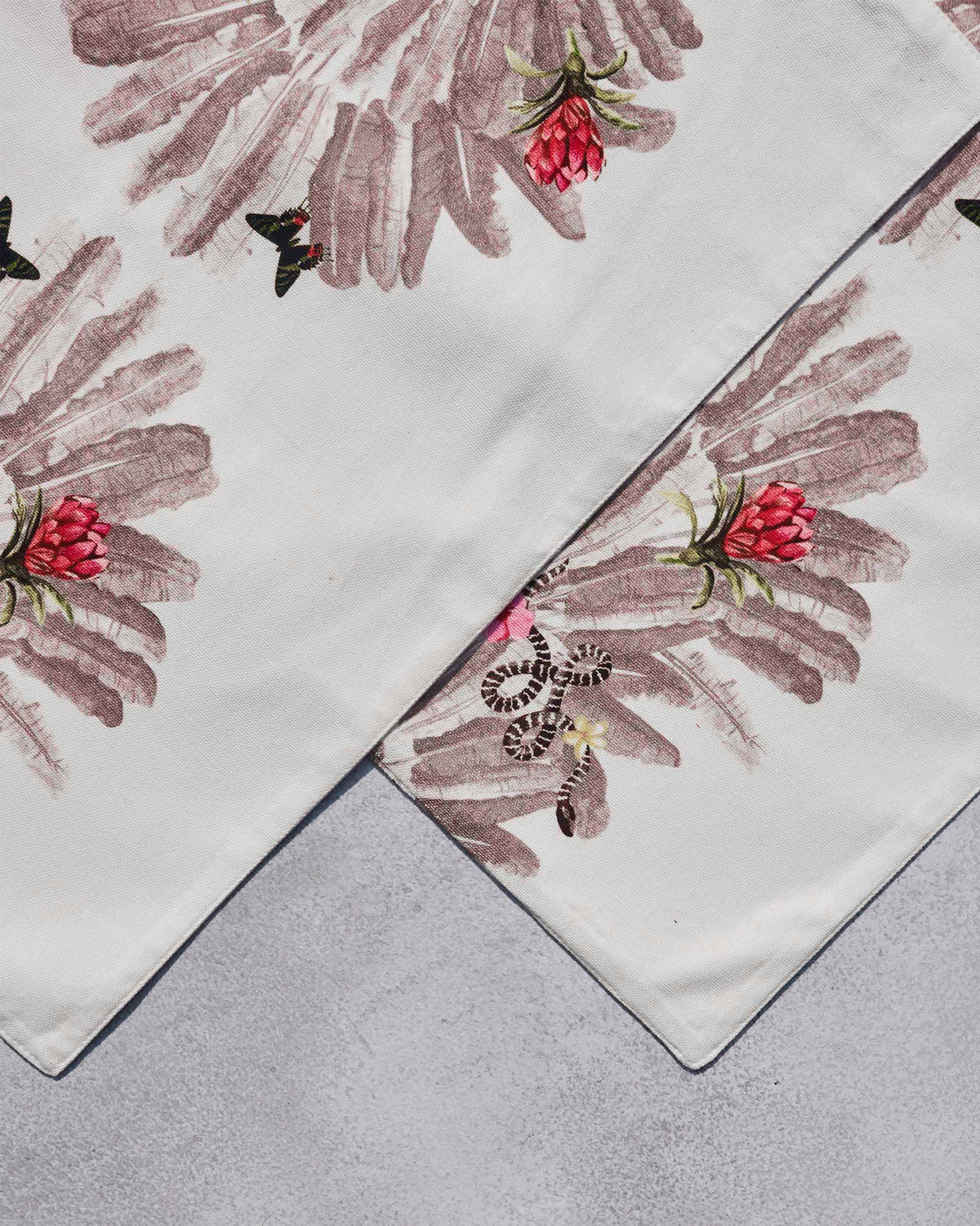Close-up of overlapping Ravenala Placemats showing the red flower print.