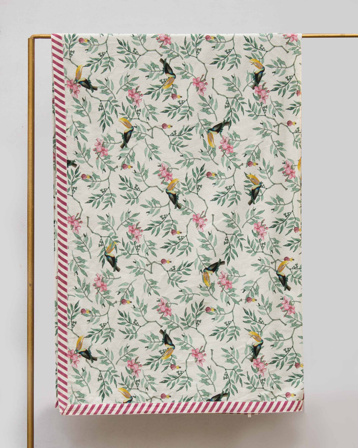 Nakano bed cover fabric hanging to show toucan print and maroon striped border.
