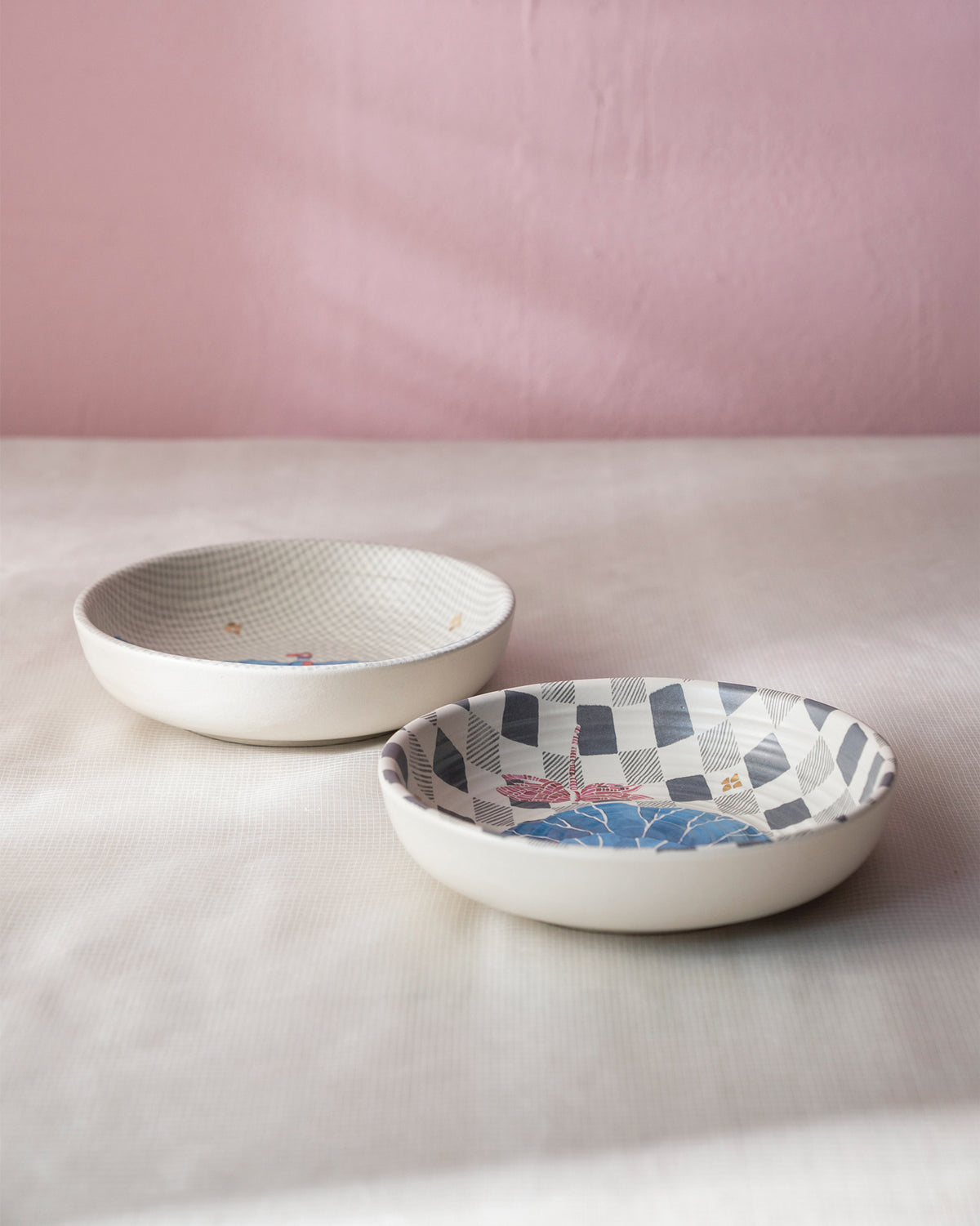 Nectar shallow bowls with blue leaf and pink dragonfly motifs on geometric interiors.