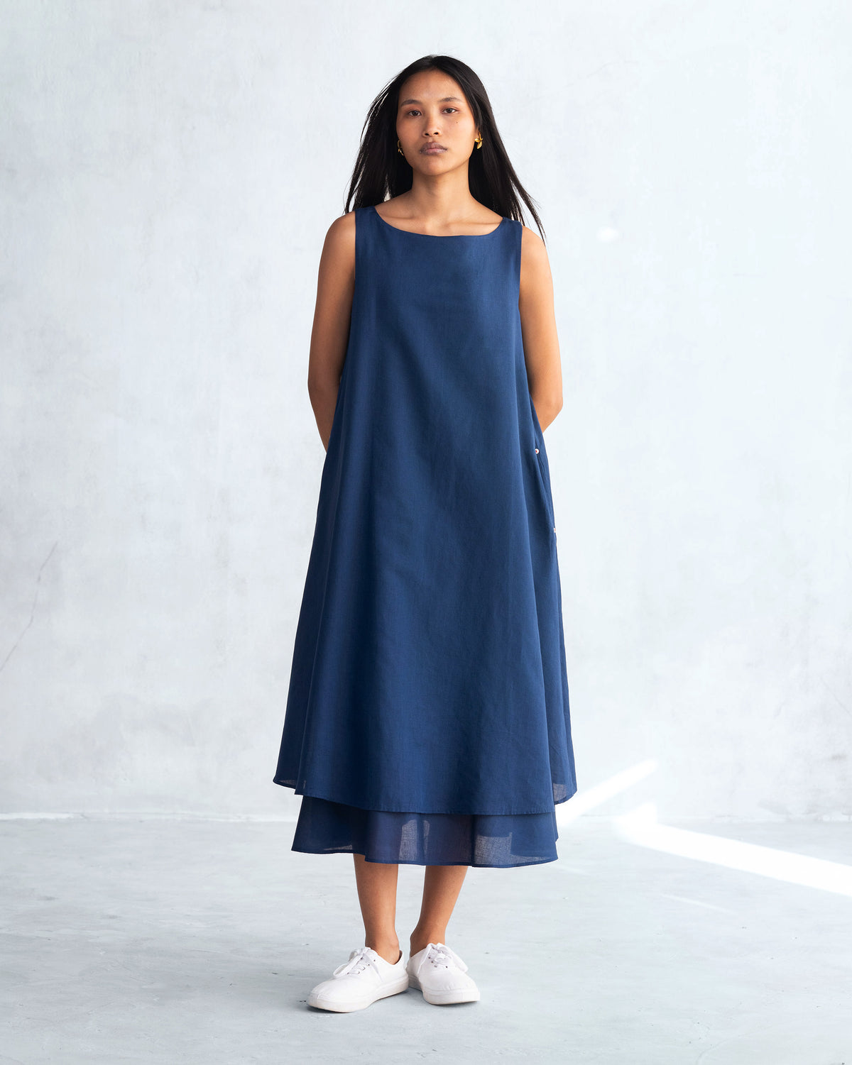 Person wearing a navy Double layer dress with a layered hem.