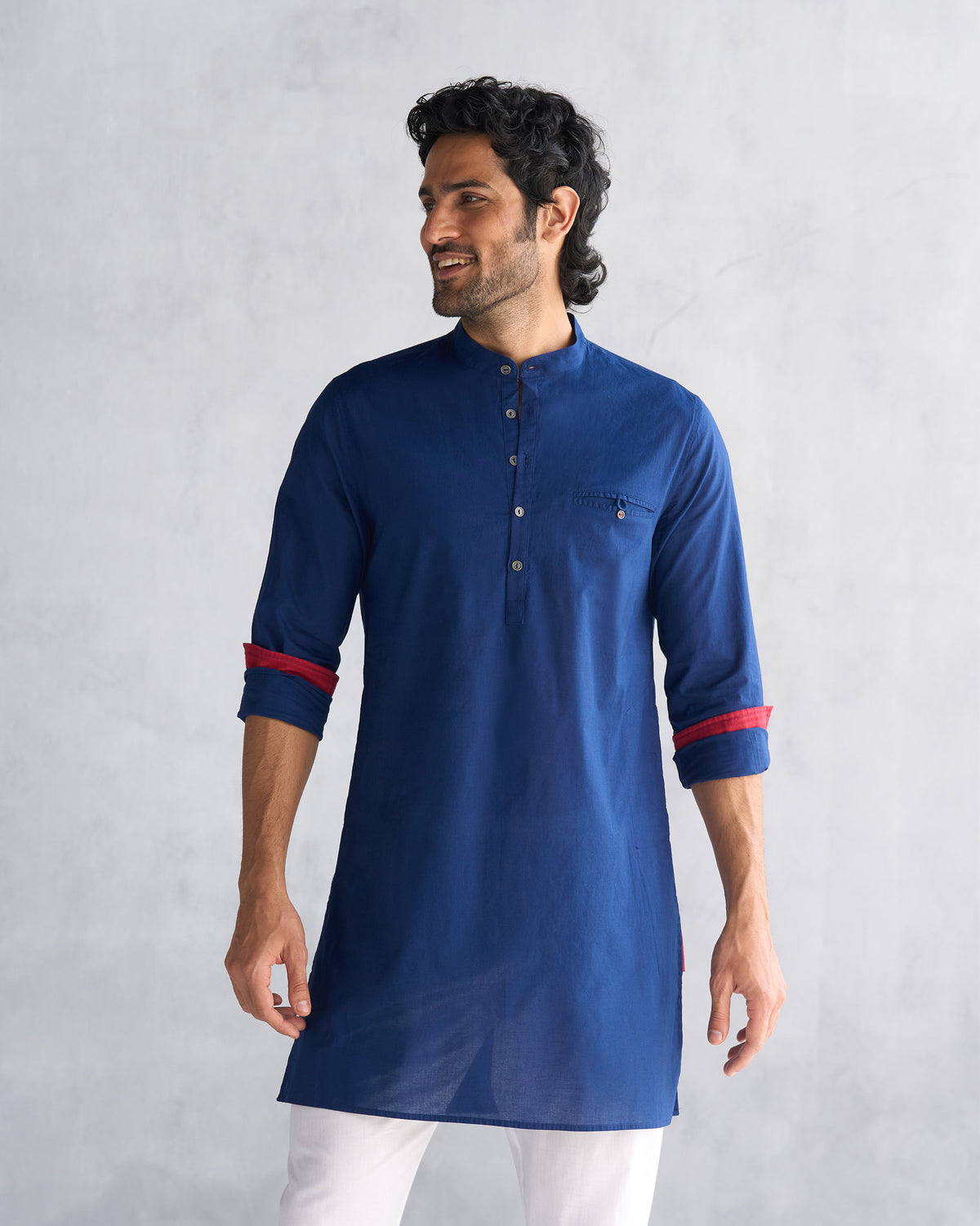 Person wearing a navy Pondicherry kurta with red cuff lining.