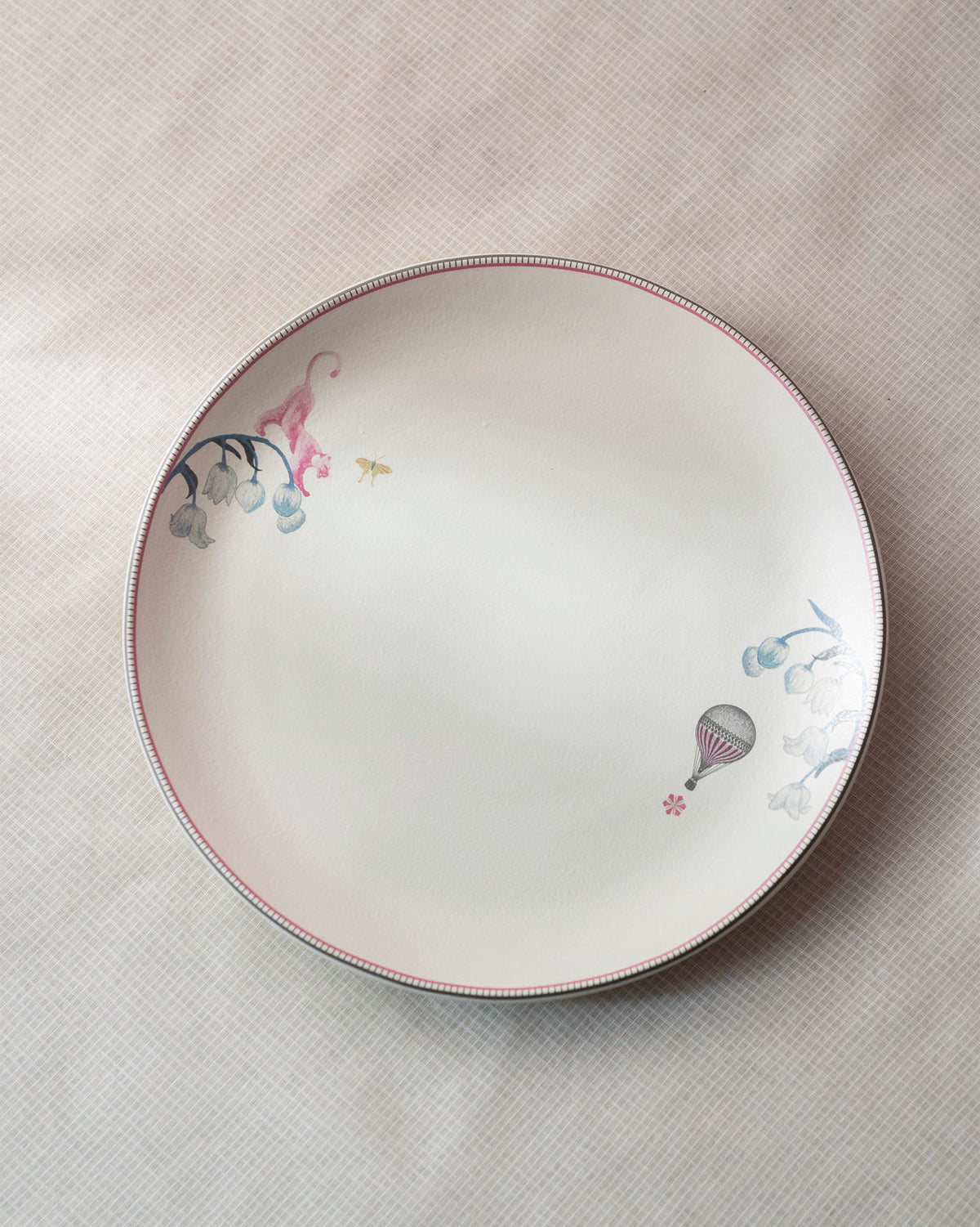 Cream Myra dinner plate with a pink animal, blue flowers and a hot-air balloon.