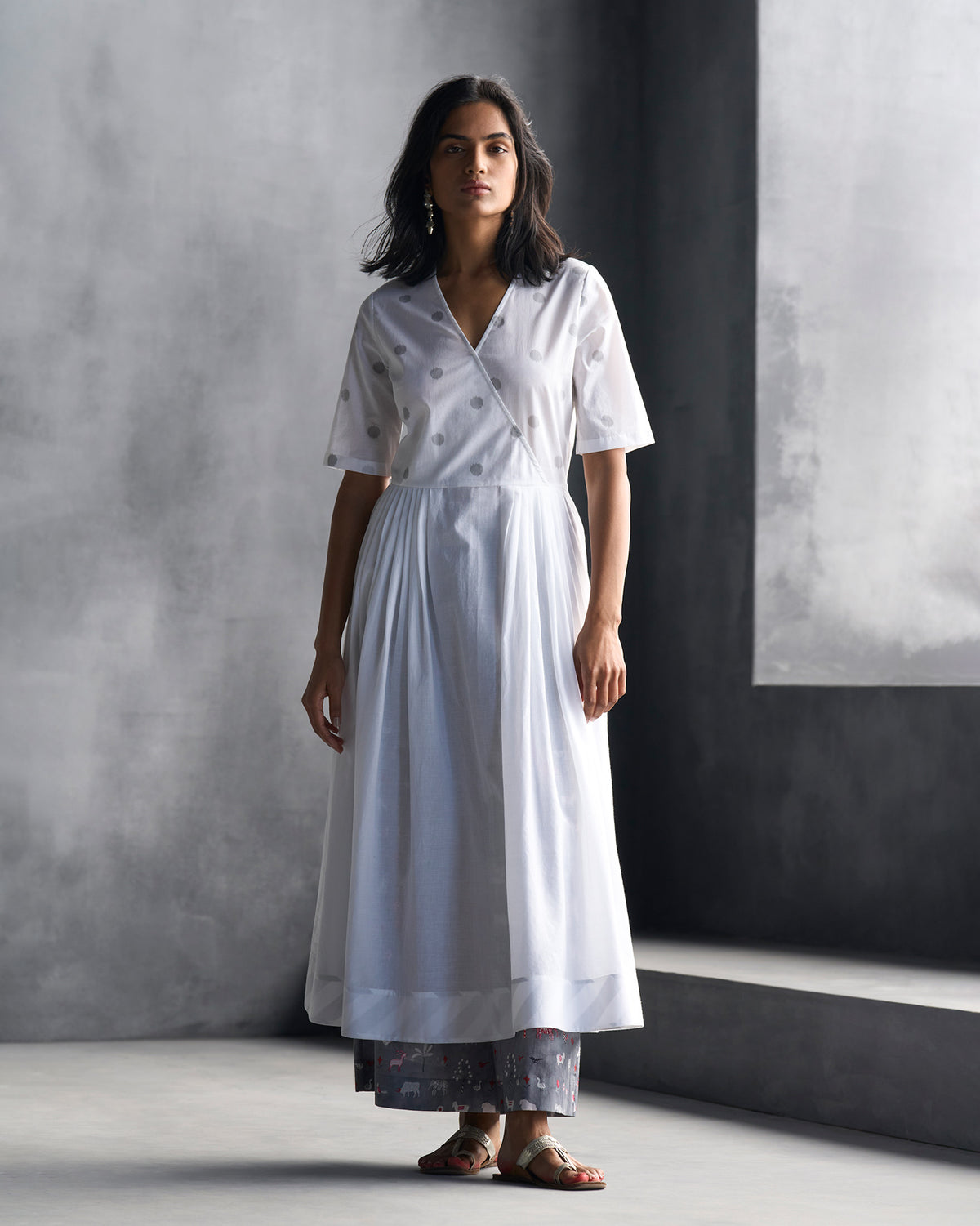 Person wearing a white front-overlap yoke kurta with grey ikat dots.
