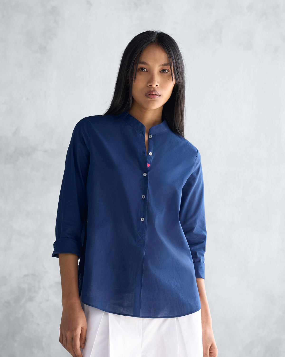 Person wearing a navy mandarin collar top.