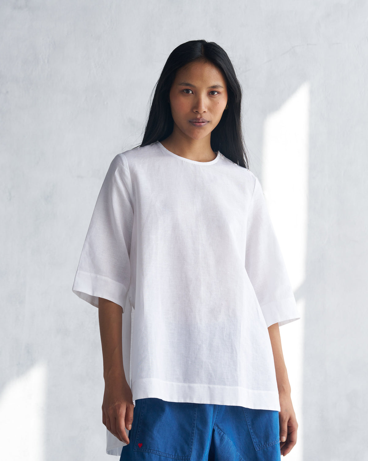 Person wearing a white High Slit Top with elbow sleeves.