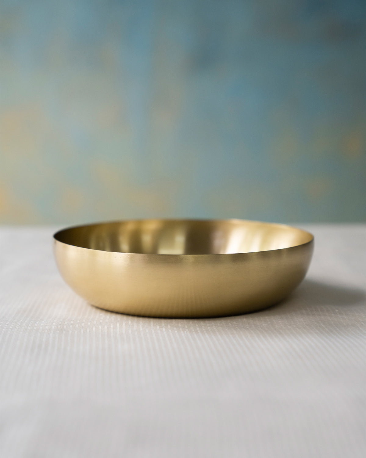 Wide brass Madhu shallow bowl with a thin rim.