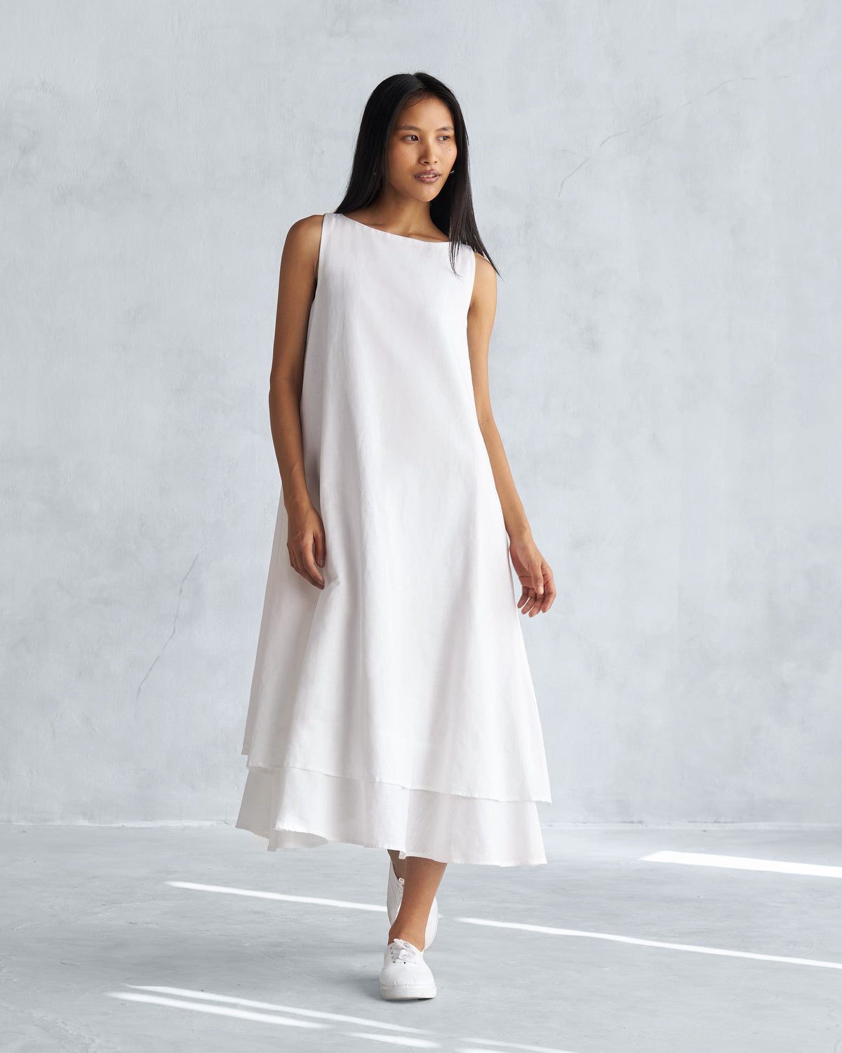 Person wearing a white Double layer dress with a layered hem.
