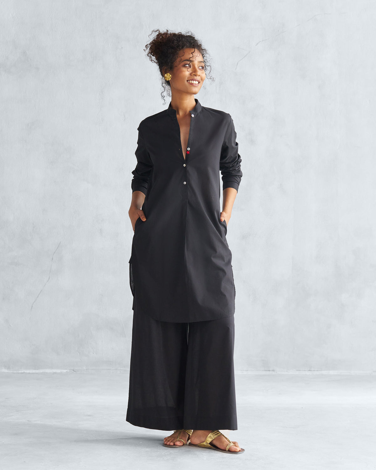 Person wearing a black mid-length kurta with a mandarin collar.