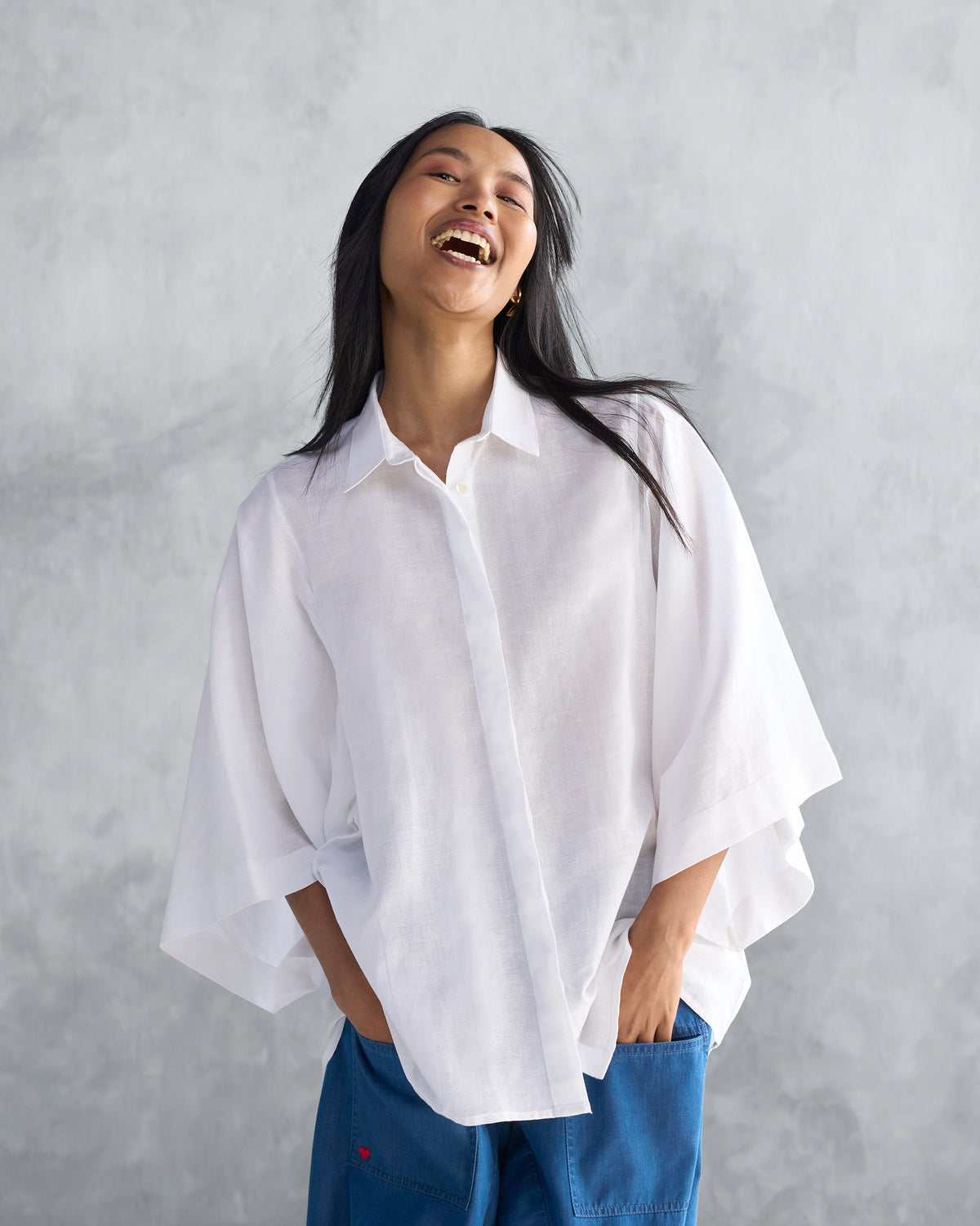 Person wearing a white Drop Armhole Shirt with wide flared sleeves.