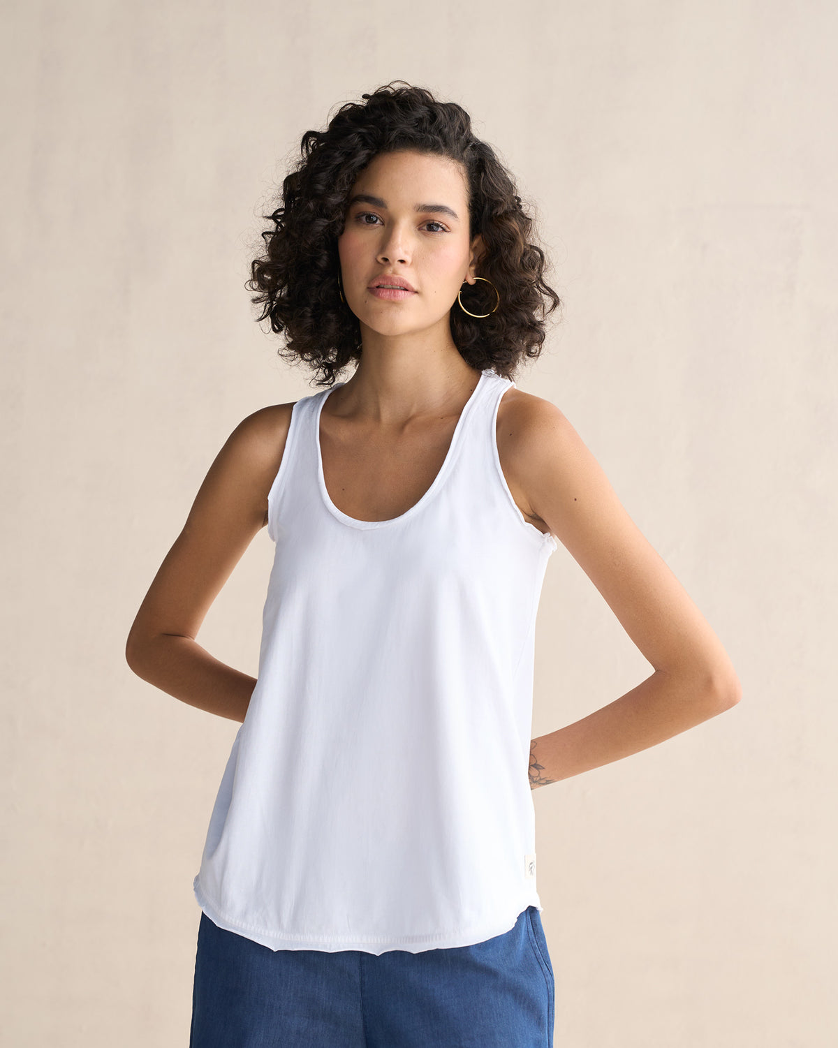 Person wearing a white Ukiyo racerback tank with a scoop neck.