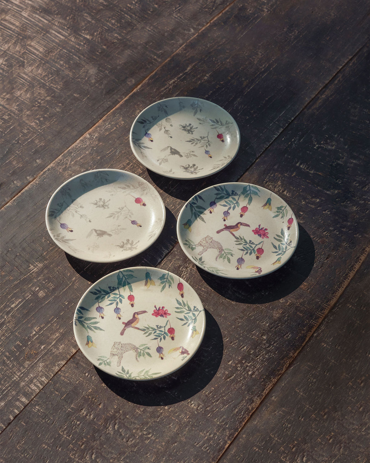 Set of four Nakano tapas plates in colour and grey toucan-leopard prints.