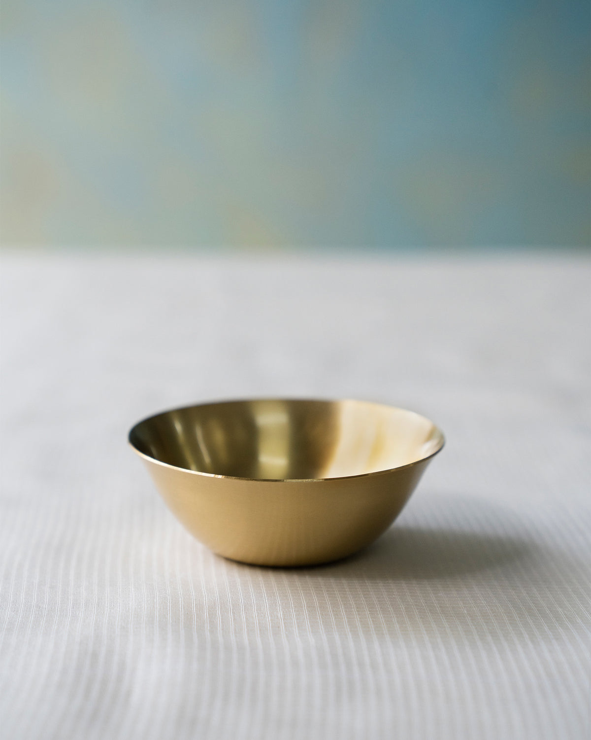 Brushed brass Madhu katori with a flared rim and rounded base.