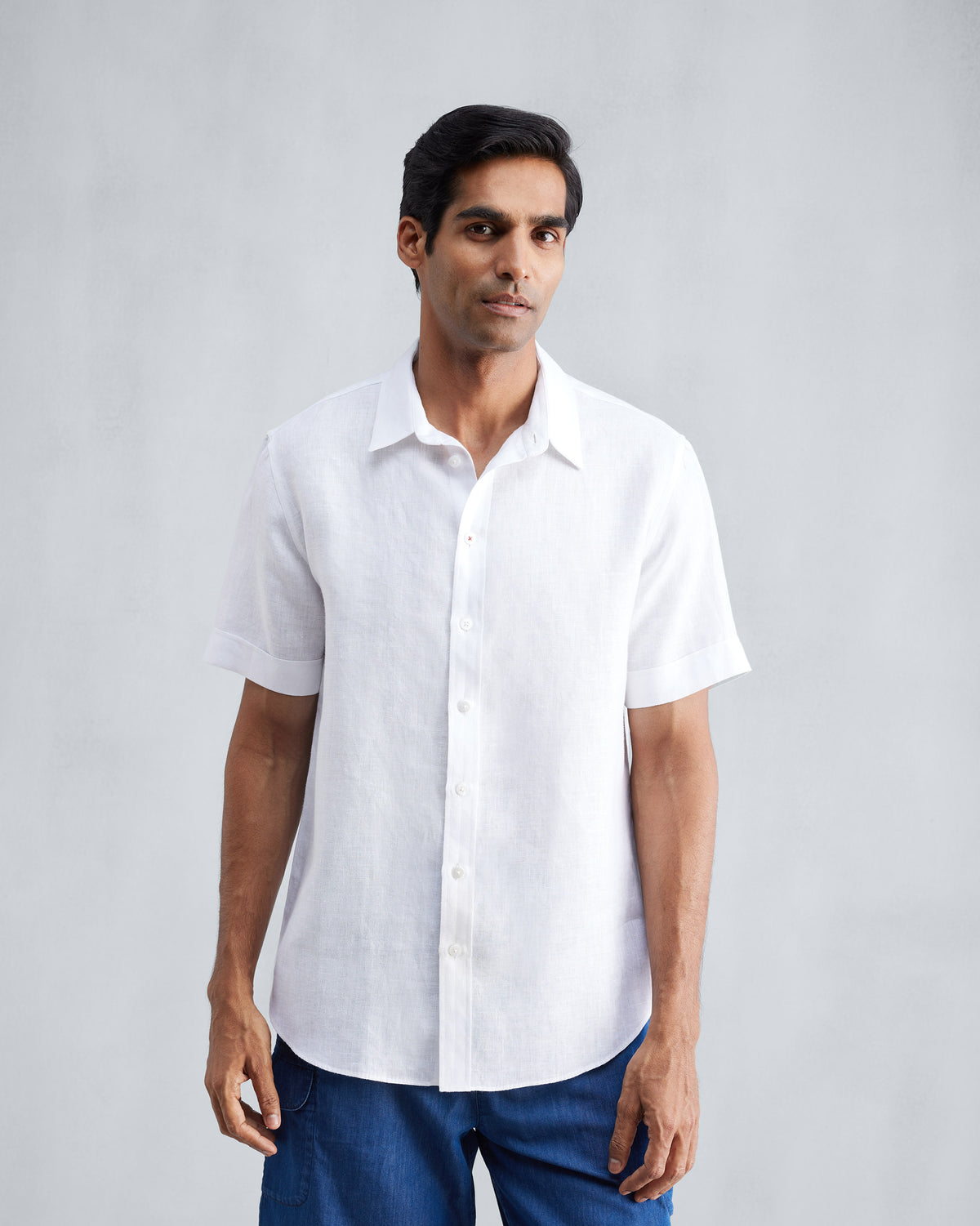 Person wearing a white half-sleeve shirt with a classic collar.