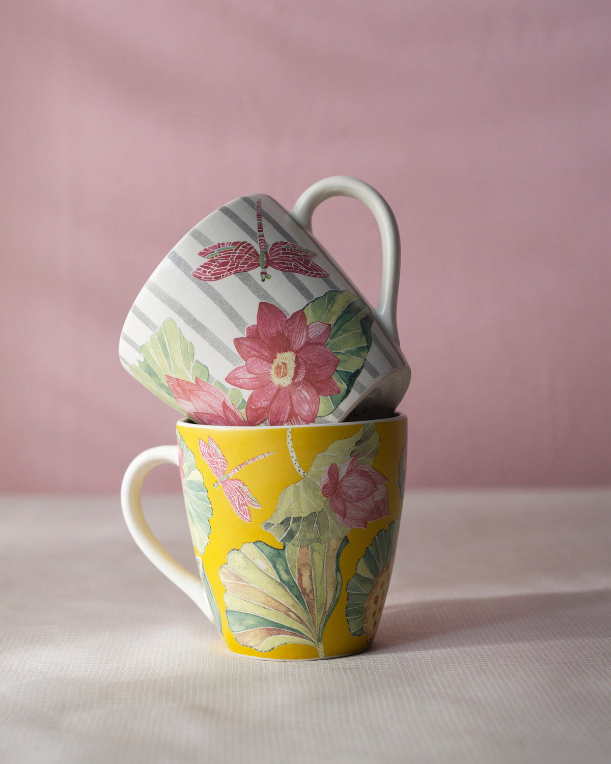 Stacked Lotus Garden mugs showing pink lotus and mustard leaf designs.