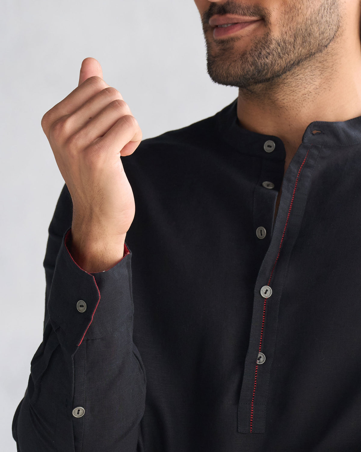 Close-up of a black Chandni Chowk kurta collar with red contrast stitching.