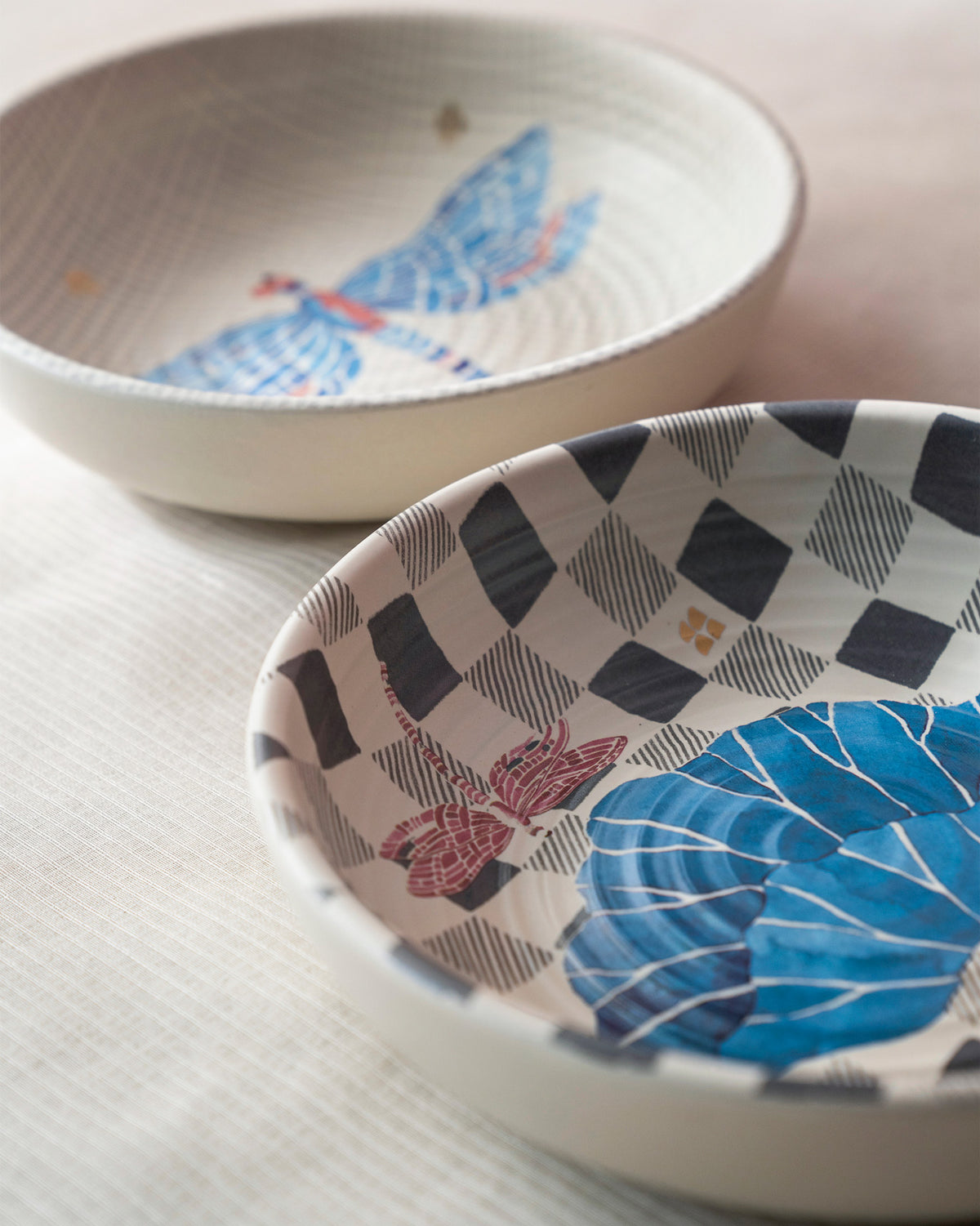 Nectar shallow bowl with a blue leaf and pink dragonfly on a black-and-white checkered ground.