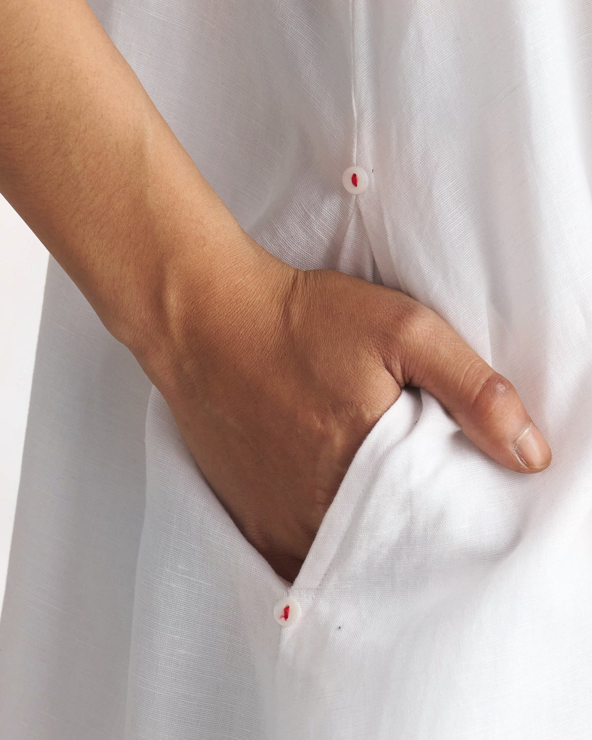 Close-up of a white Double layer dress pocket with small buttons.