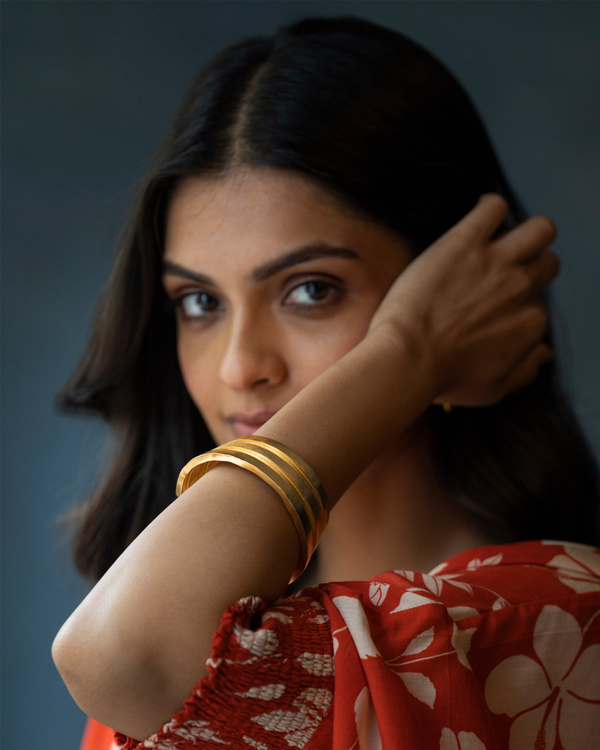 Person wearing stacked gold Ridge bangles on the wrist.