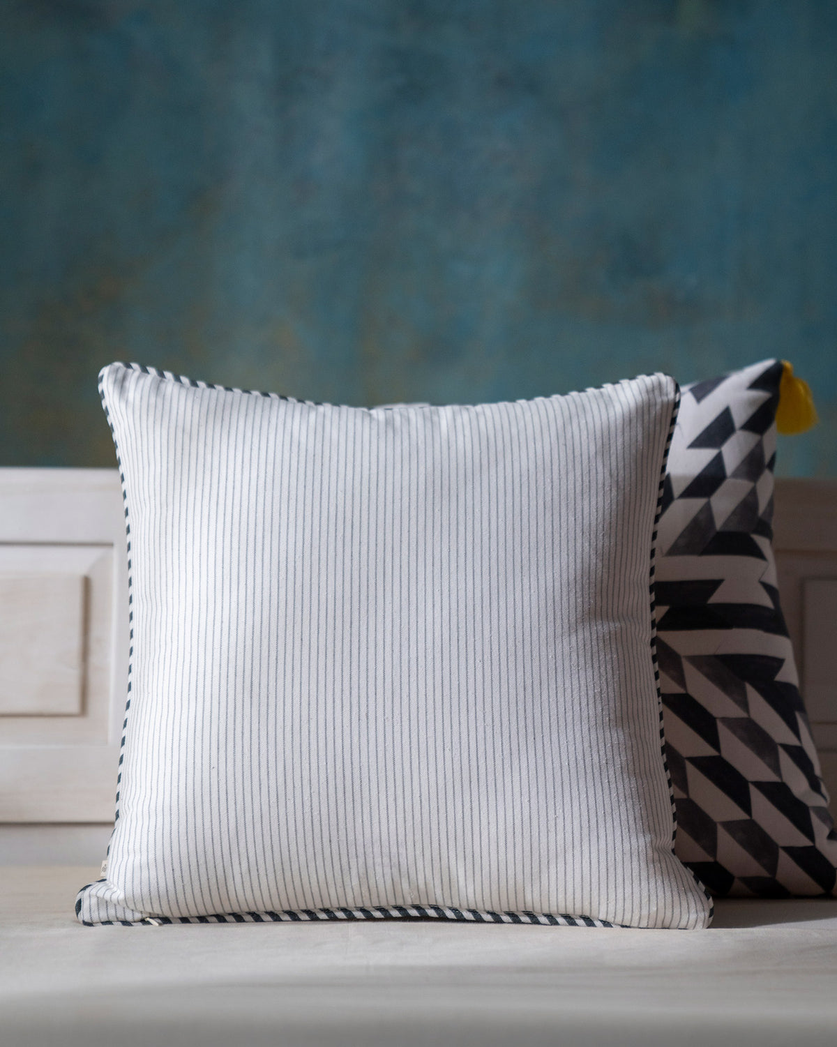 Back of Winter Wonderland Cushion Cover in white pinstripe with a dark piped edge.