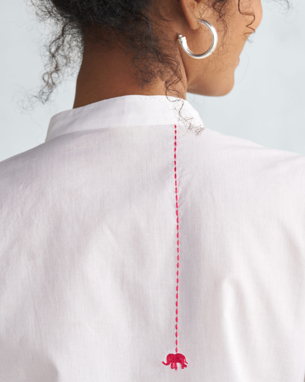 Close-up of a white kurta back with a red elephant embroidery.