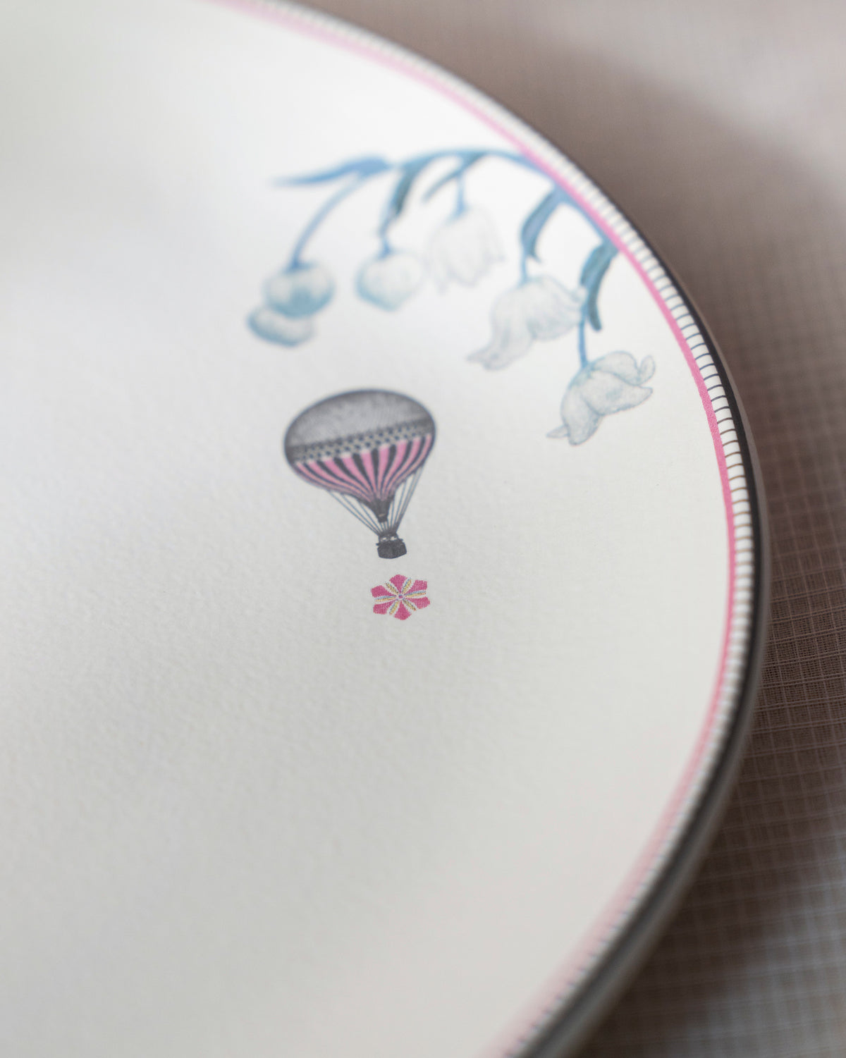 Close-up of a Myra dinner plate showing a striped hot-air balloon motif.