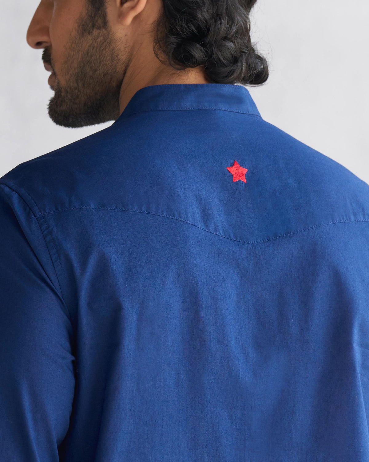 Close-up of a navy Pondicherry kurta showing a red star on the back yoke.