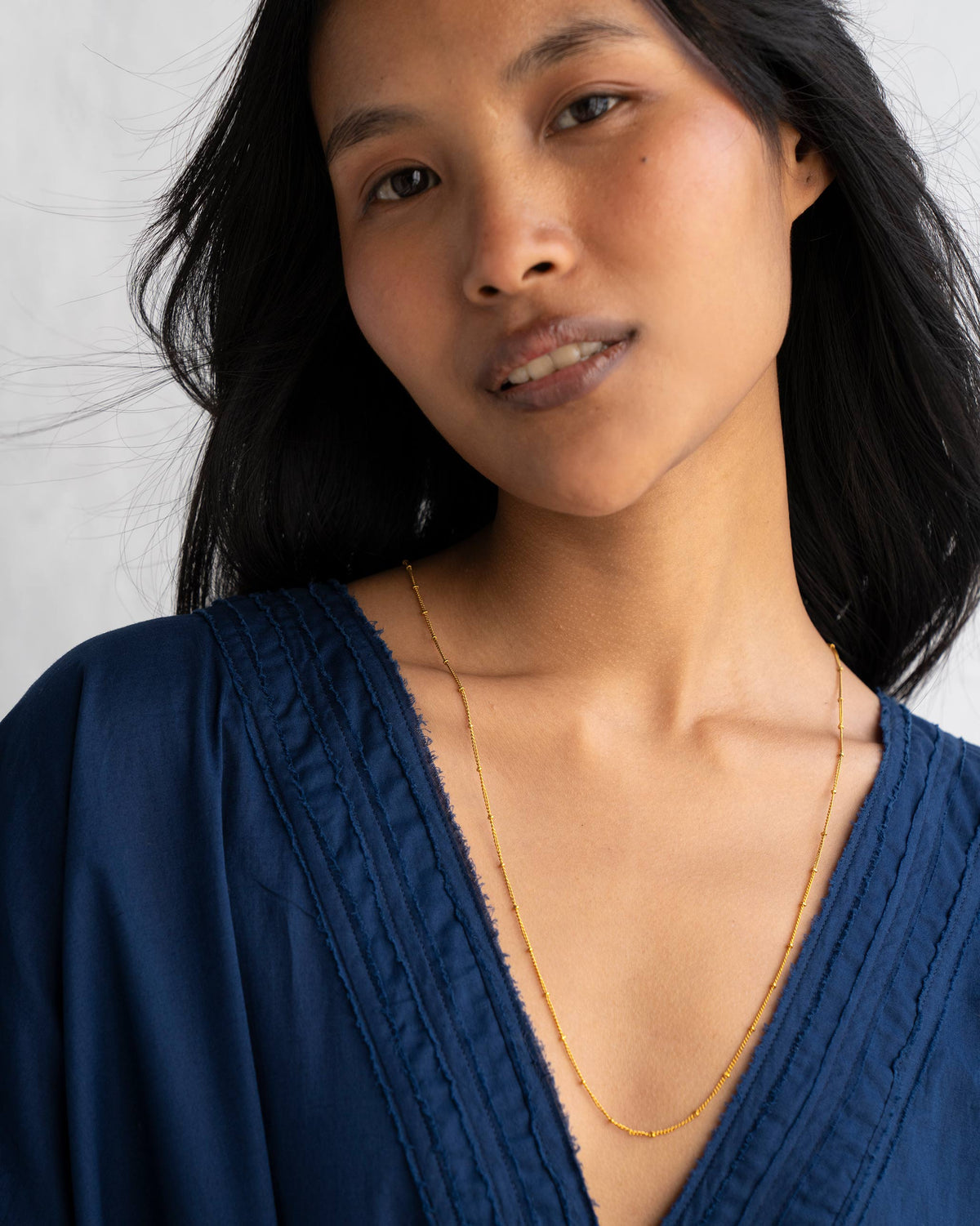 Person wearing medium Boondi Chain in gold.