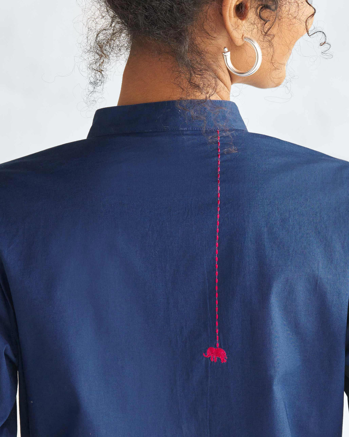 Close-up of the back of a navy mid-length kurta with a red elephant motif.