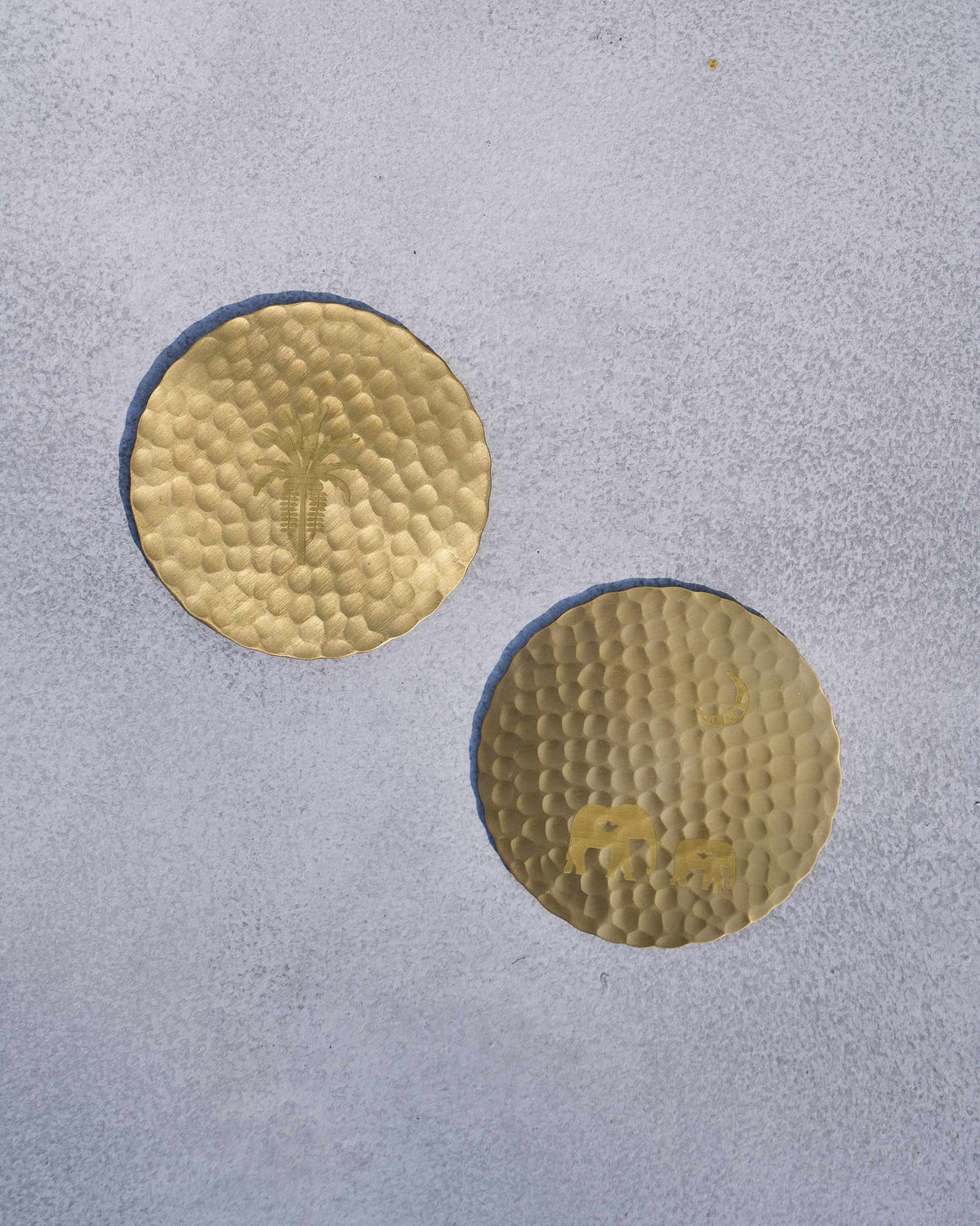 Pair of Ele palm coasters with a palm motif and hammered texture.