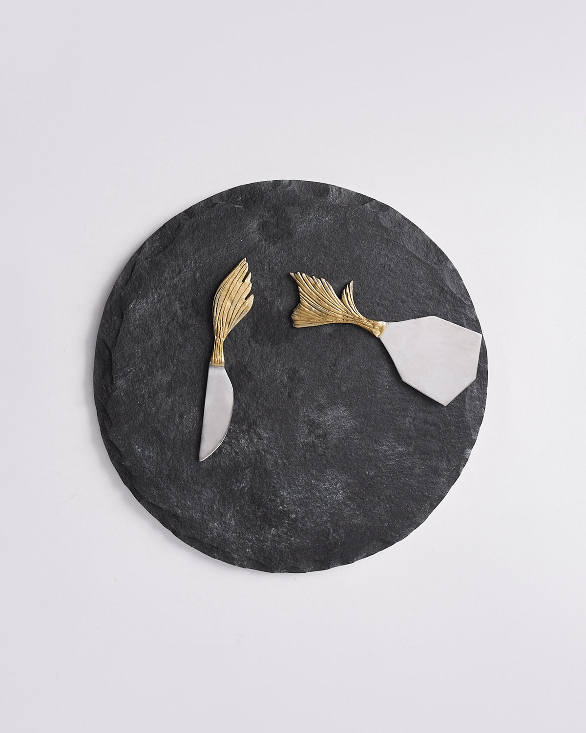 Marina cheese platter set with two gold leaf-handled knives on a dark board.