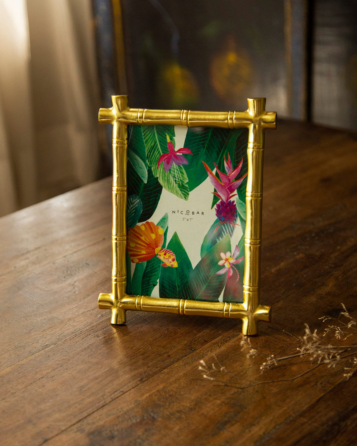 Gold bamboo photo frame standing with a tropical Nicobar print.