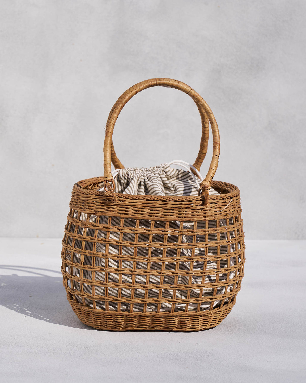 Khasi Lunch Basket with two handles and a striped pouch inside.