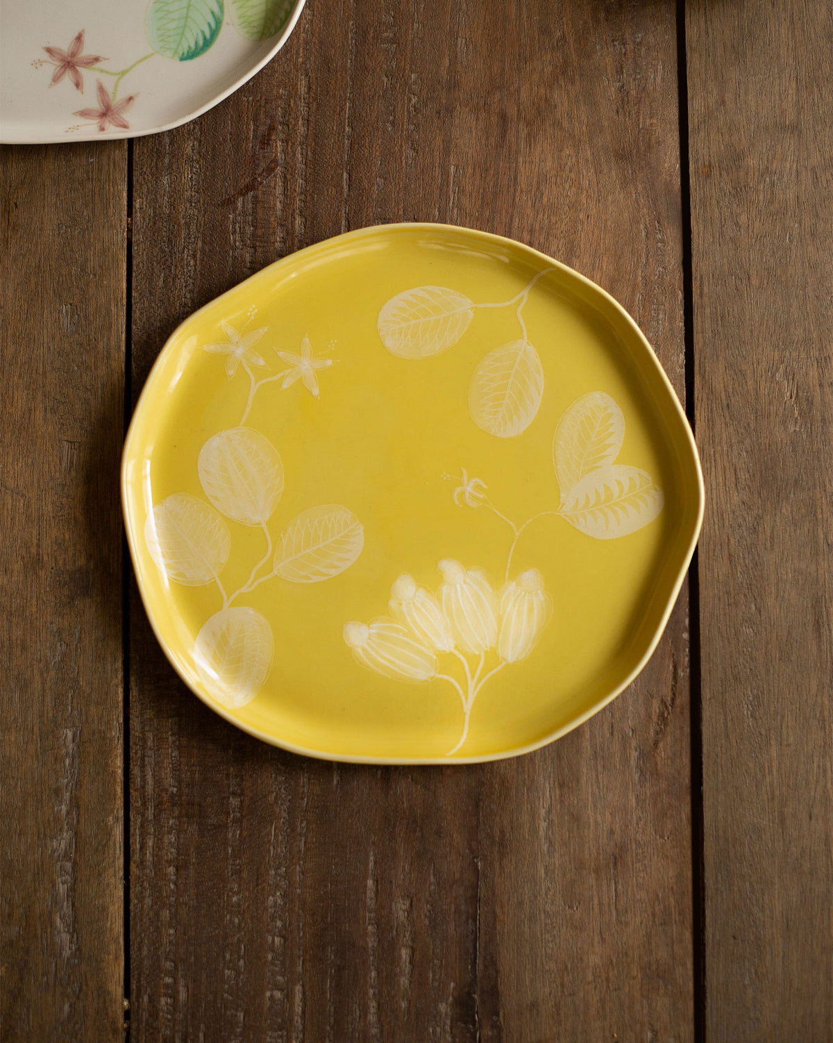 Yellow Mhadei quarter plate with white leaf and flower motifs.