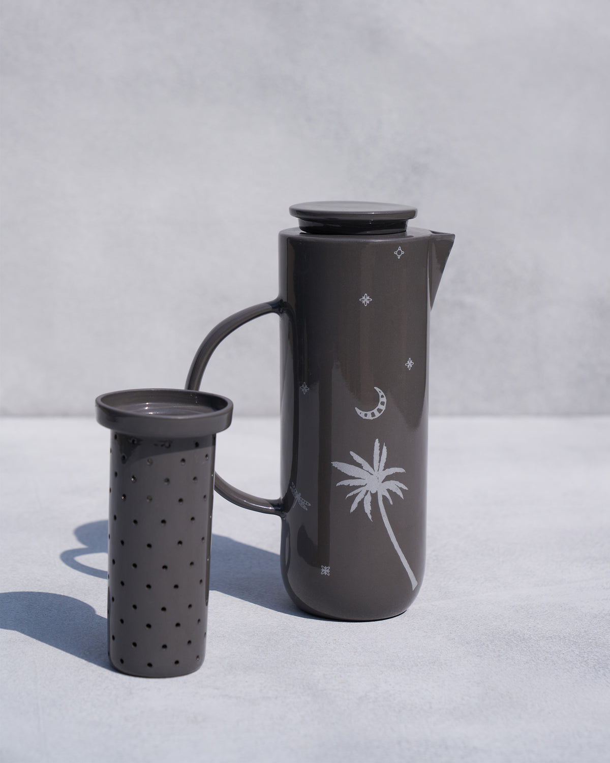Perforated infuser standing in front of the Taramandal Carafe.