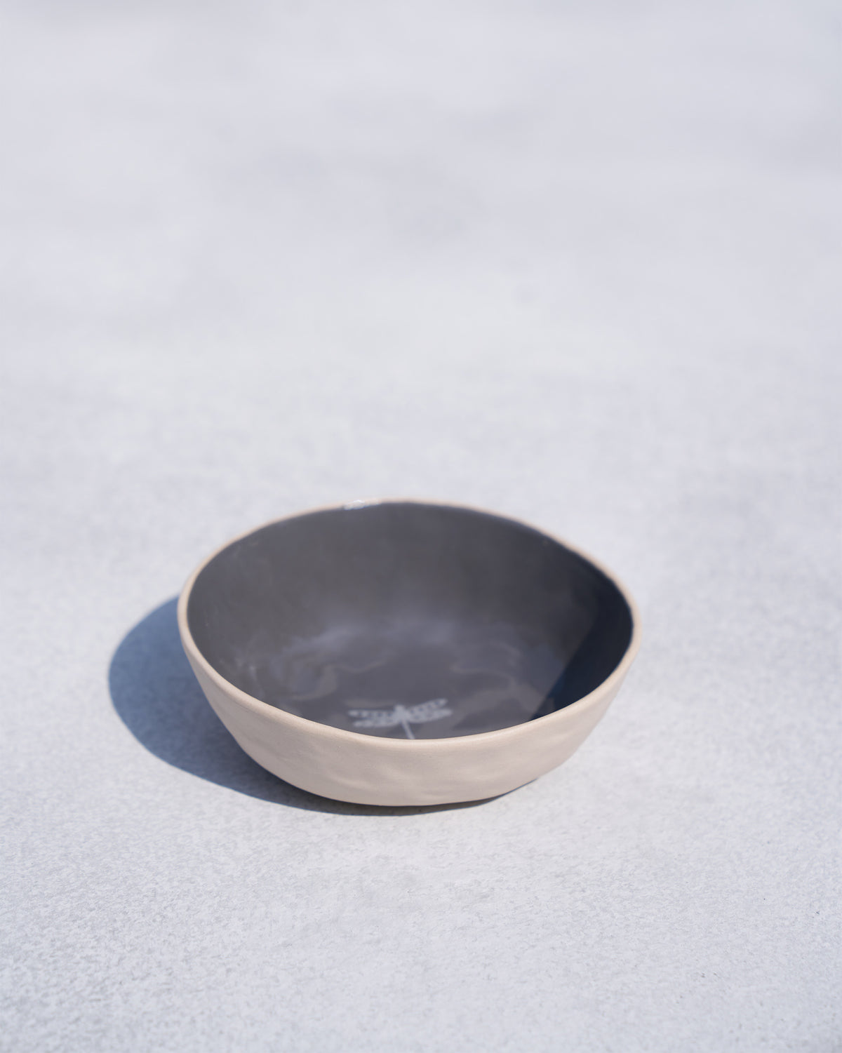 Side view of Kangra Katori with a grey interior and cream outside.
