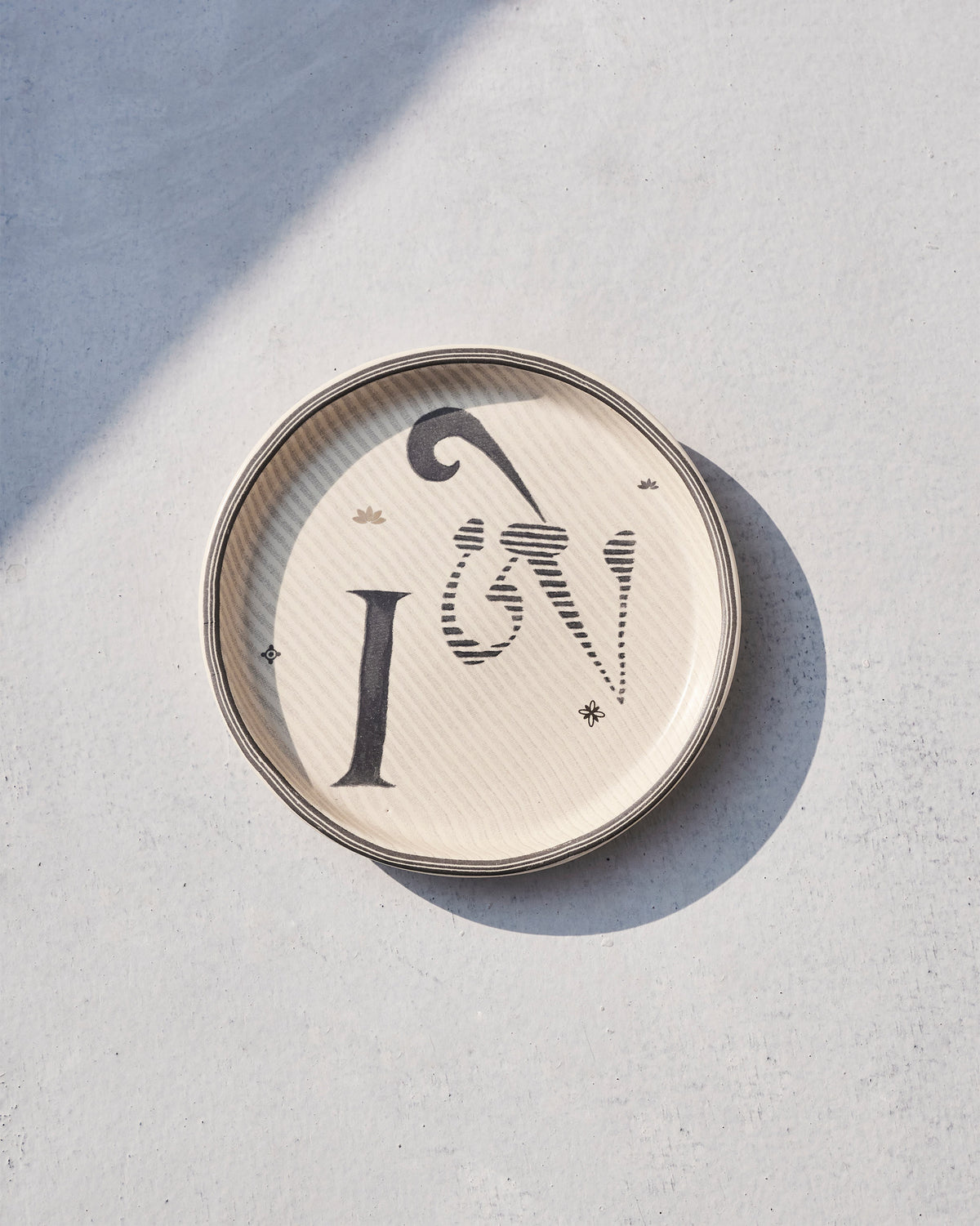 Akshar Coaster with a letter I, seen from above at a slight angle.