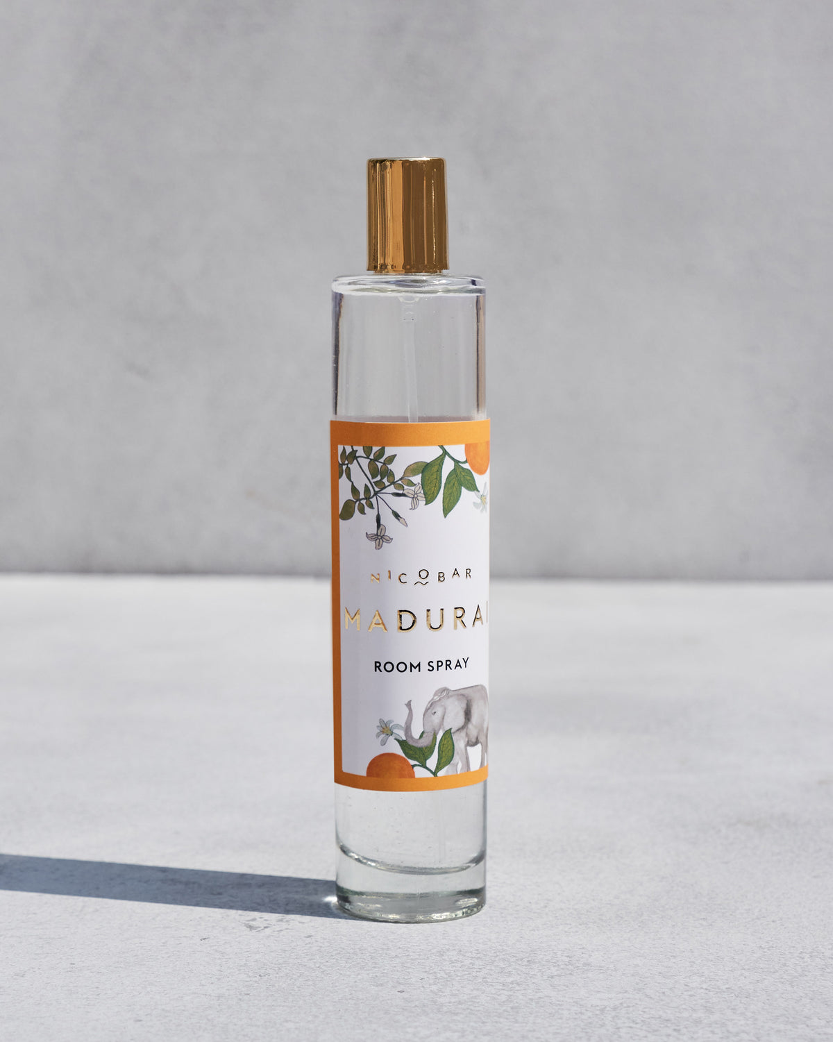 Madurai Room Spray in a glass bottle with an orange and white label.