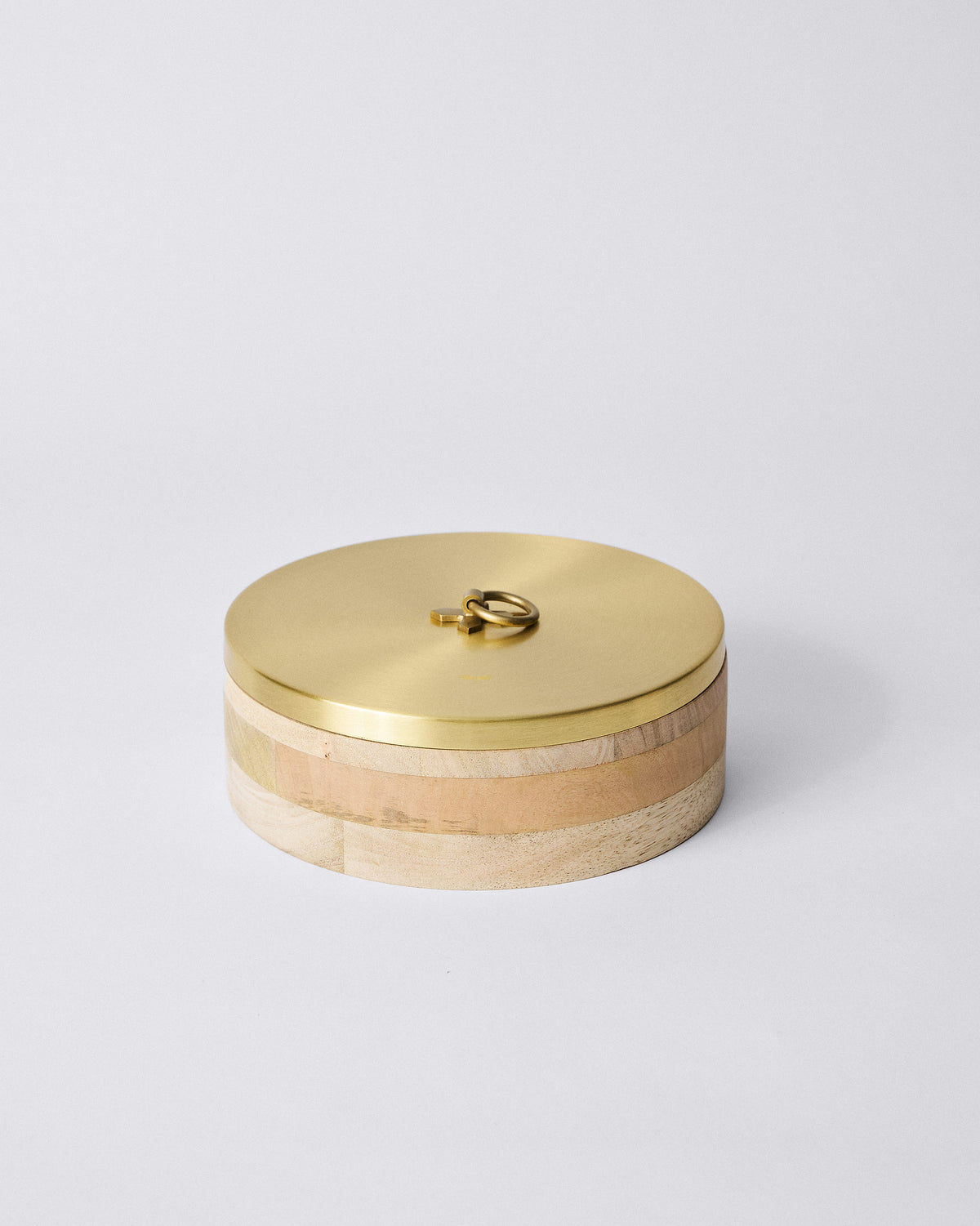 Round wooden roti box with a brushed brass lid and ring handle.