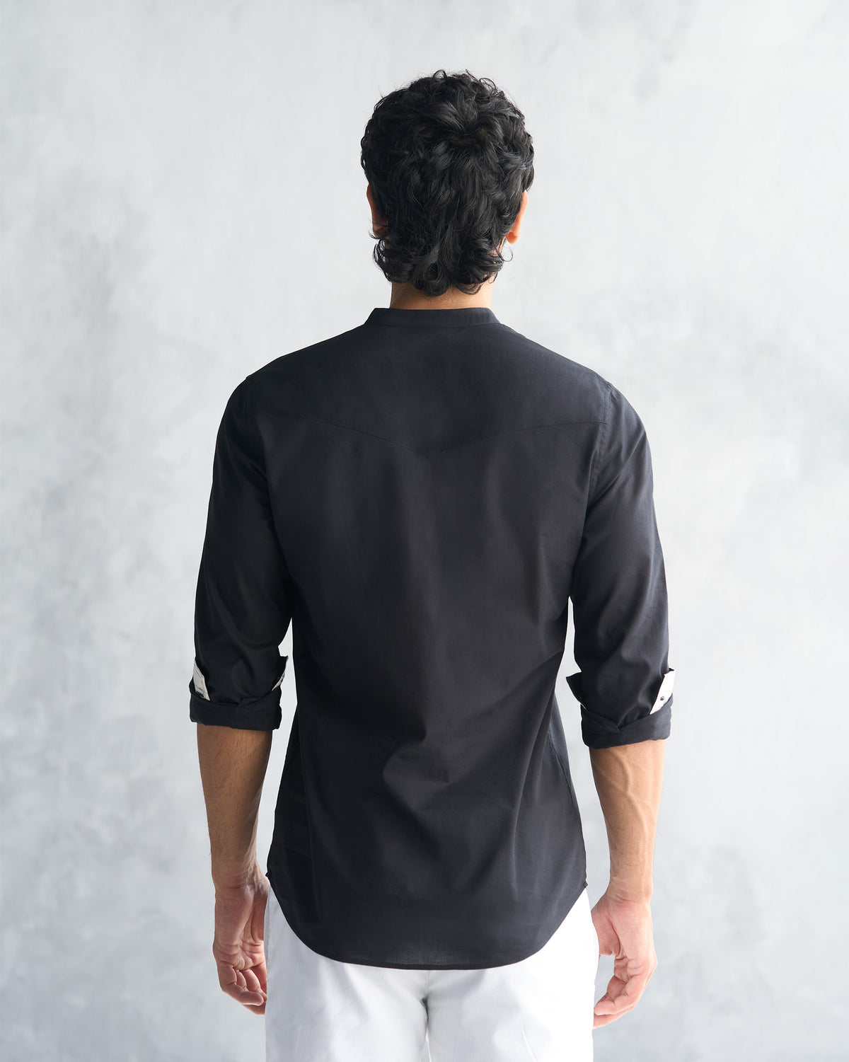 Back of a black Pondicherry shirt worn by a person.