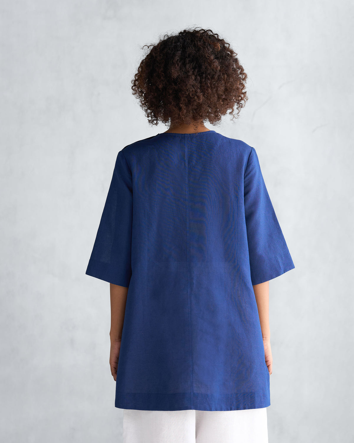 Back of a navy High slit top worn by a person.