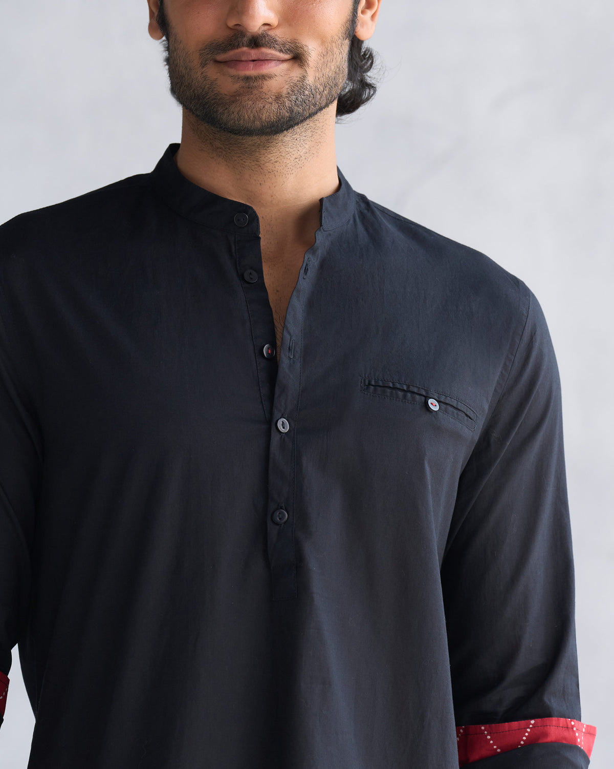 Close-up of a black Pondicherry kurta showing mandarin collar and chest pocket.