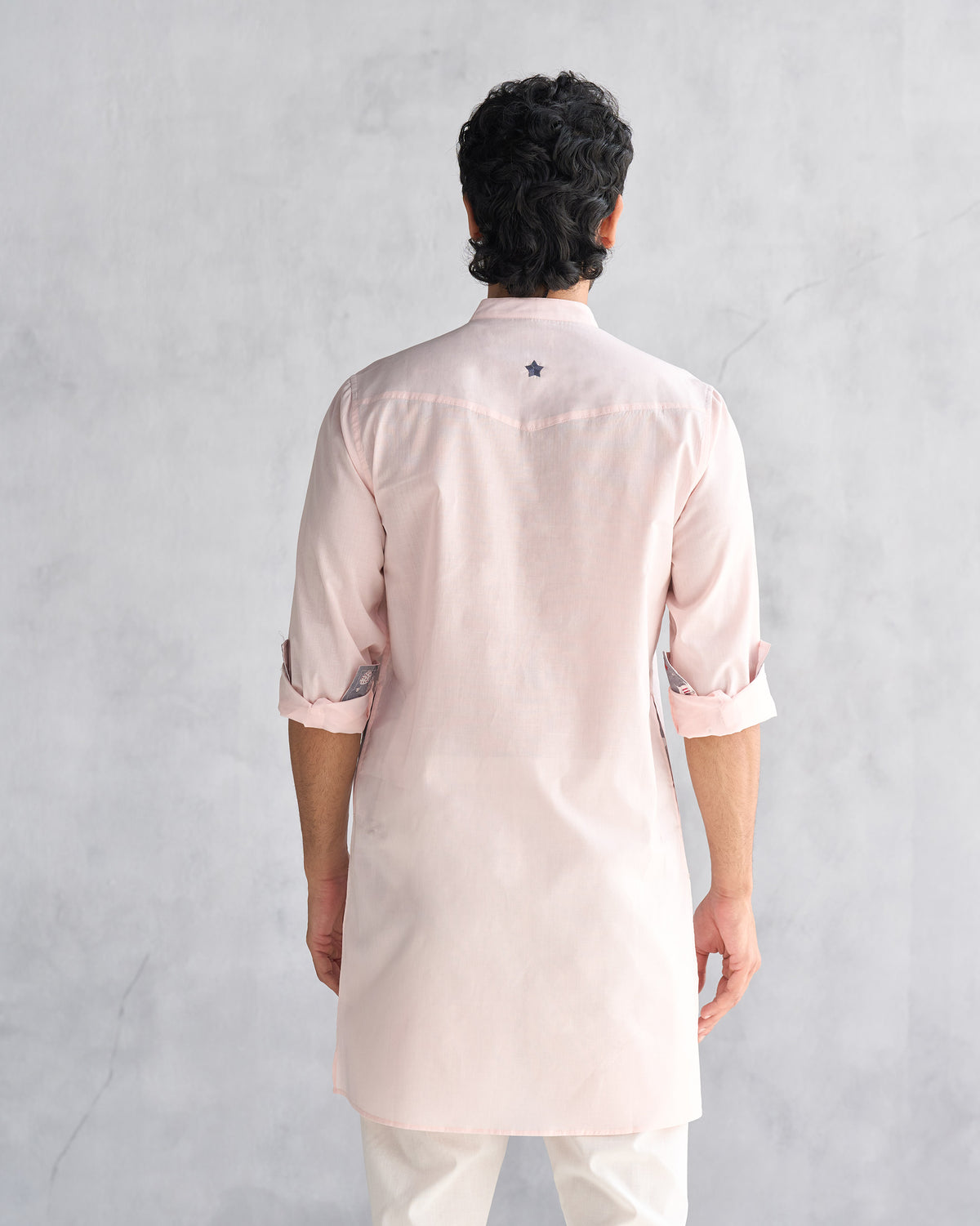 Back of a pink Pondicherry kurta with a blue star on the yoke.