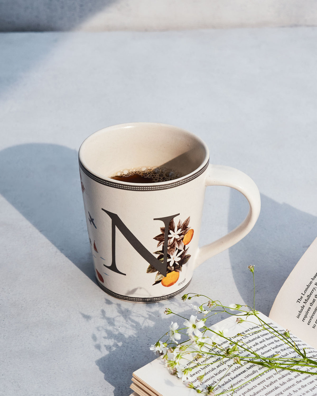 Coffee in a Nico mug with the letter N and citrus motifs.