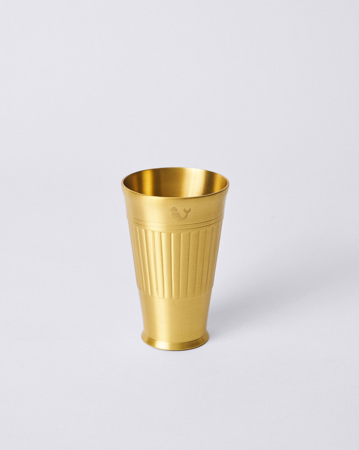 Brass Dariya lassi glass with vertical ribs and an engraved creature.