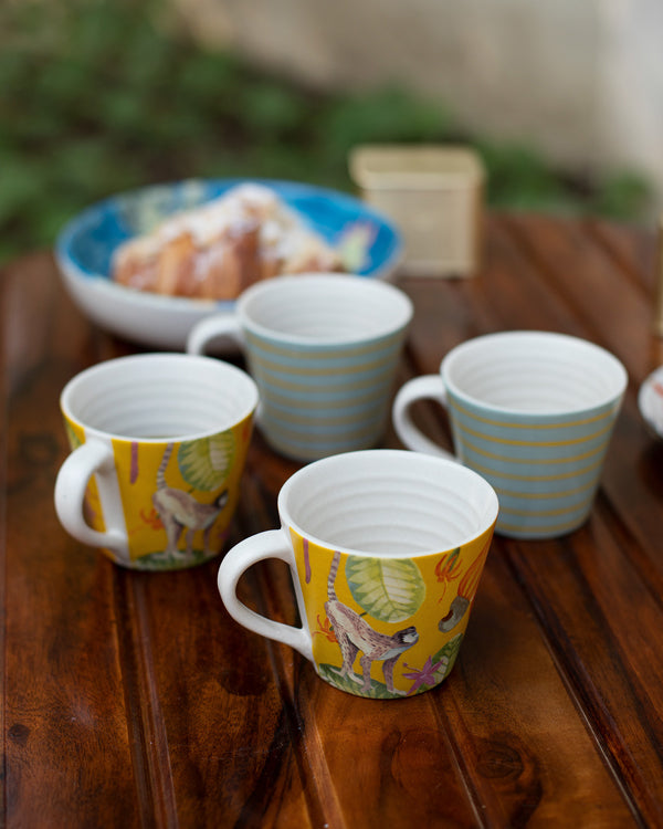 Four Mahi espresso mugs with monkey print and yellow stripes on a table.