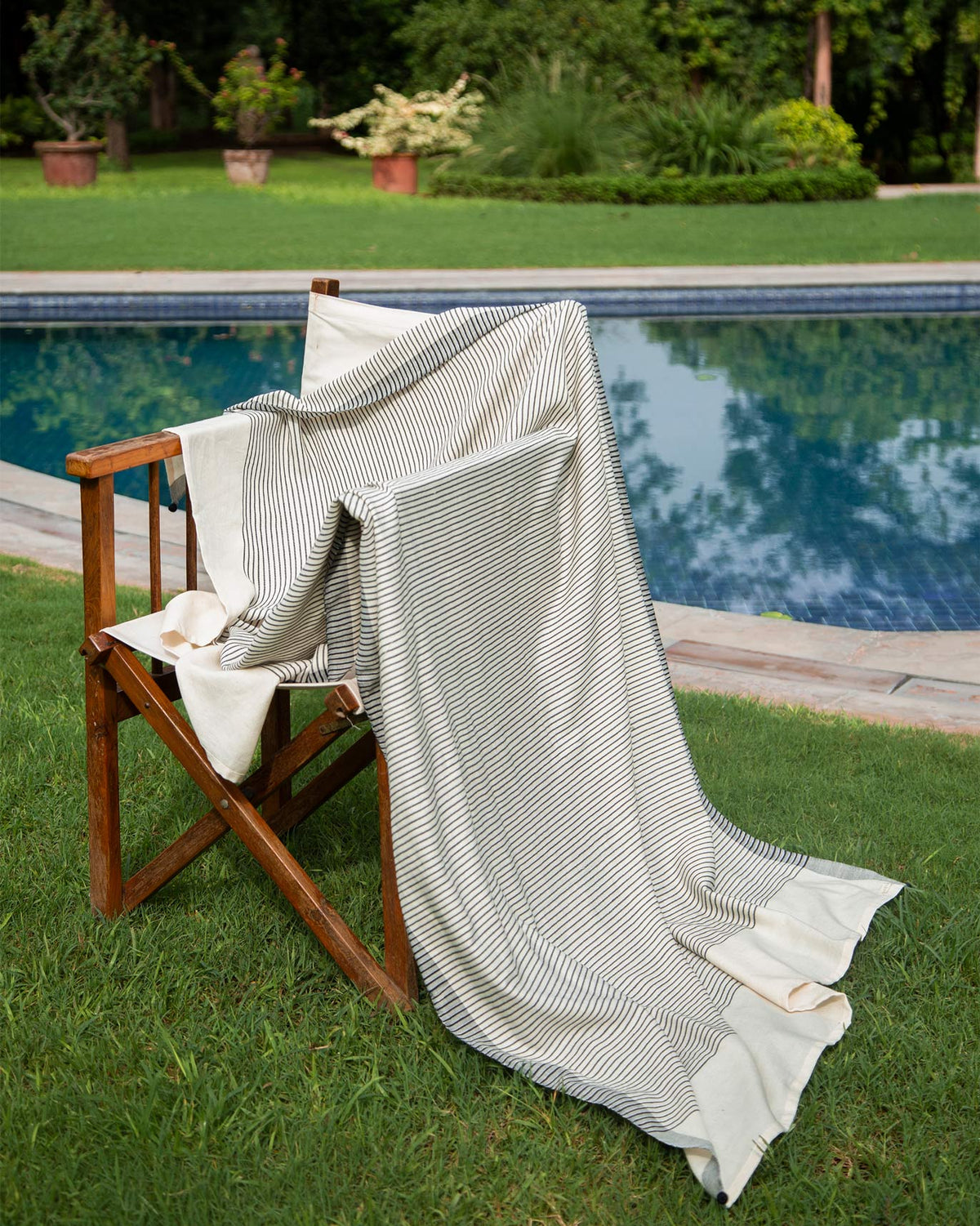 Coast Towel in black stripes draped over a wooden chair.